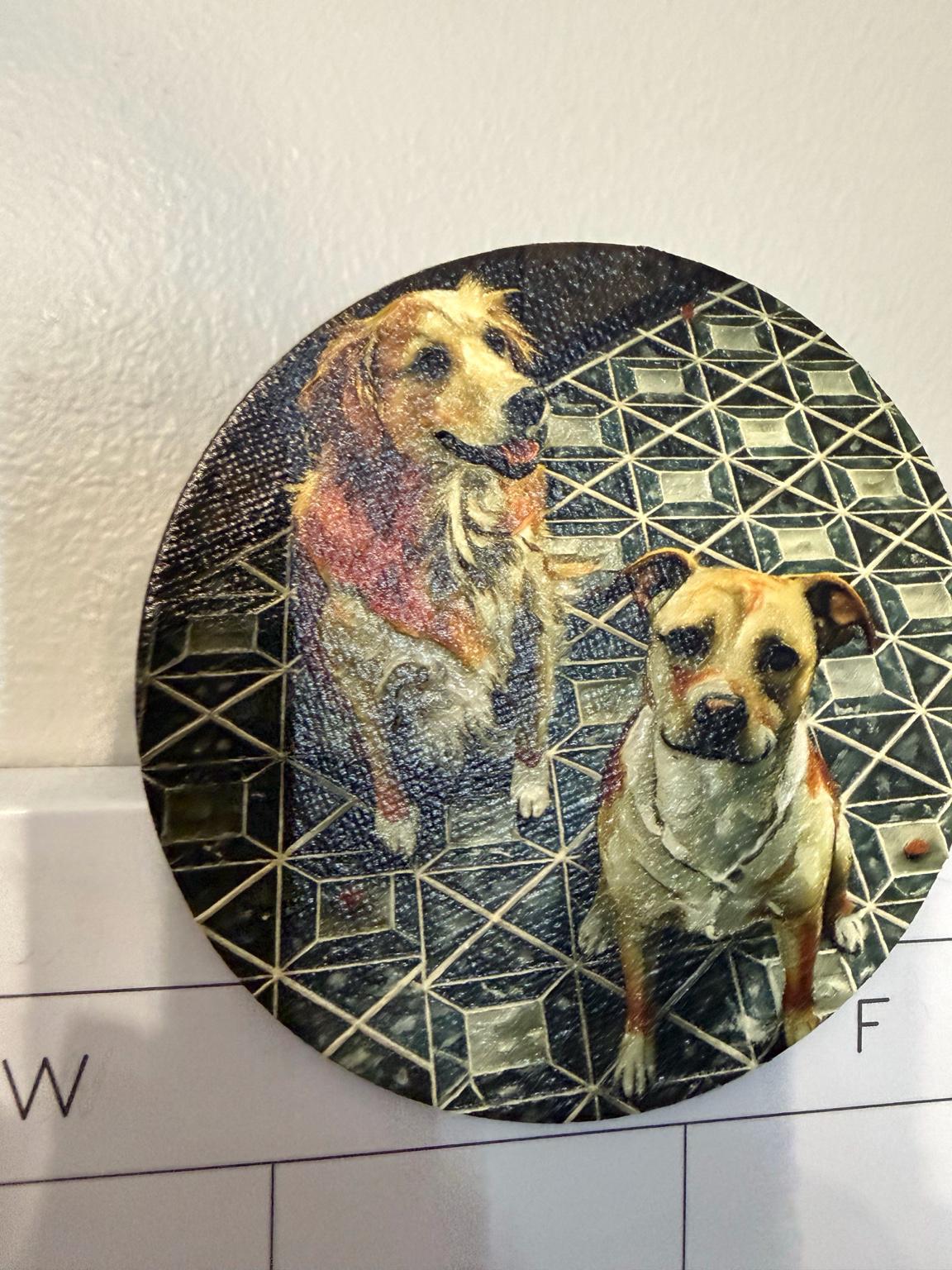 Custom Pet Portrait Magnet with a textured brushstroke portrait of two dogs on a geometric dark pattern, shown against a white wall above a calendar page