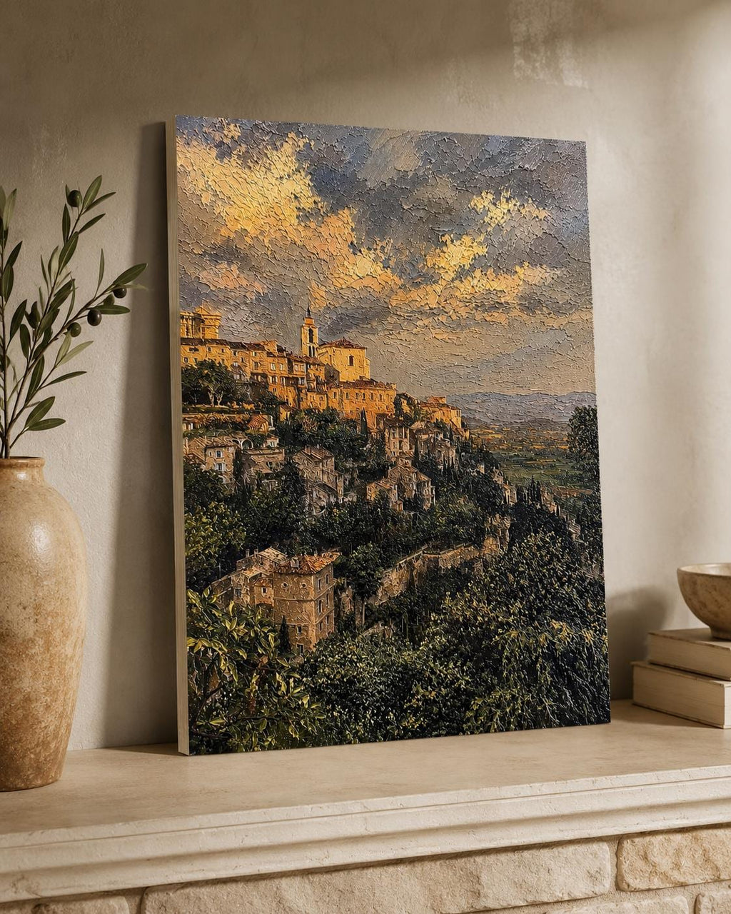 Tuscany Hill Town Textured Painting Print canvas leaning against a wall on a stone mantelpiece, styled beside a ceramic vase with greenery and stacked books