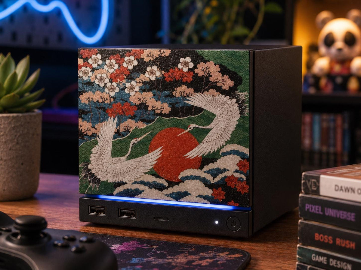 Japanese Crane Steam Machine Faceplate – UV Printed Front Panel | Red Sun & Cherry Blossom Art | Custom Mini PC Cover | Gamer Gift, front view of the crane faceplate installed on the console on a wooden desk, with a black game controller, a potted succulent, and a stack of gaming books nearby