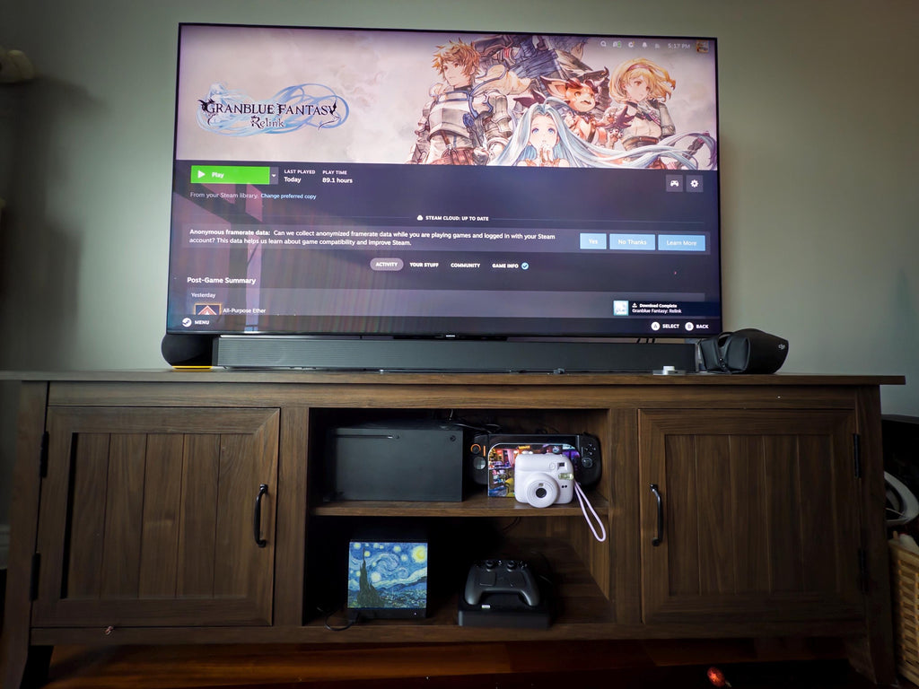 Starry Night Steam Machine Faceplate: Van Gogh Art UV Printed Magnetic Panel, wooden media cabinet with a TV showing Granblue Fantasy Relink above, and the Starry Night panel propped on the open shelf beside an Xbox, Steam Deck, instant camera and black controller