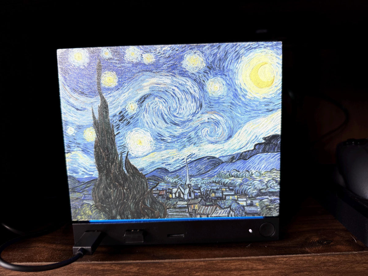 Starry Night Steam Machine Faceplate: Van Gogh Art UV Printed Magnetic Panel, angled close-up of the Steam Machine with the Starry Night faceplate installed, showing the swirling artwork on its front on a wooden surface with its cable plugged in
