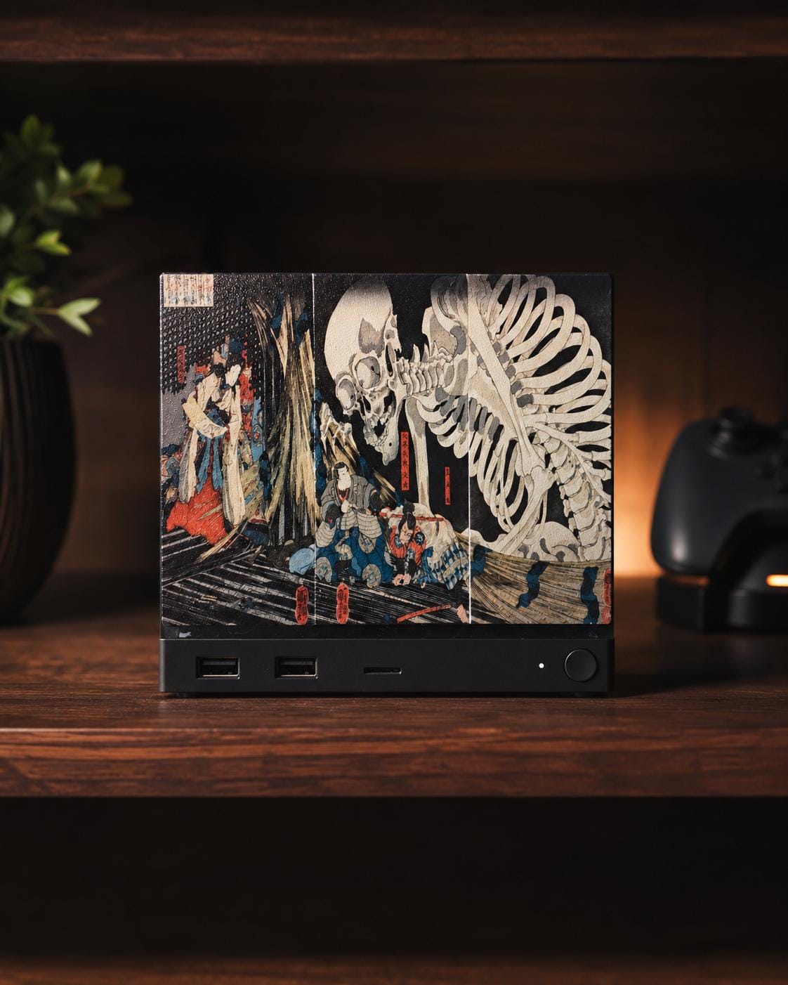 Steam Machine Faceplate, Kuniyoshi Ukiyo-e Skeleton Art, UV Printed Panel with the colossal skeleton ukiyo-e artwork, straight-on front view installed on the console on a dark wooden shelf with a plant and a game controller