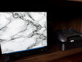 White Marble Steam Machine Faceplate | Magnetic UV Printed Panel, Minimal Desk Decor, white marble faceplate with gray veining shown installed on the Steam Machine console on a dark wooden shelf next to a black Steam controller