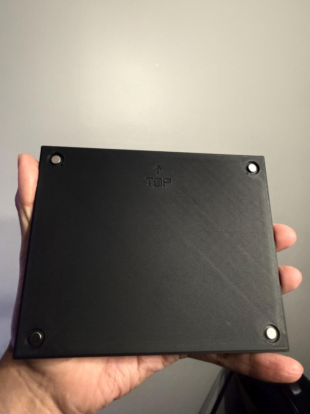 Custom Steam Machine Faceplate, Build your own Personalized Magnetic Cover Plate, Your Photo or Art UV Printed, Gamer Gift Valve Steam, back view of the black faceplate held in a hand, showing its four corner magnets and embossed TOP label