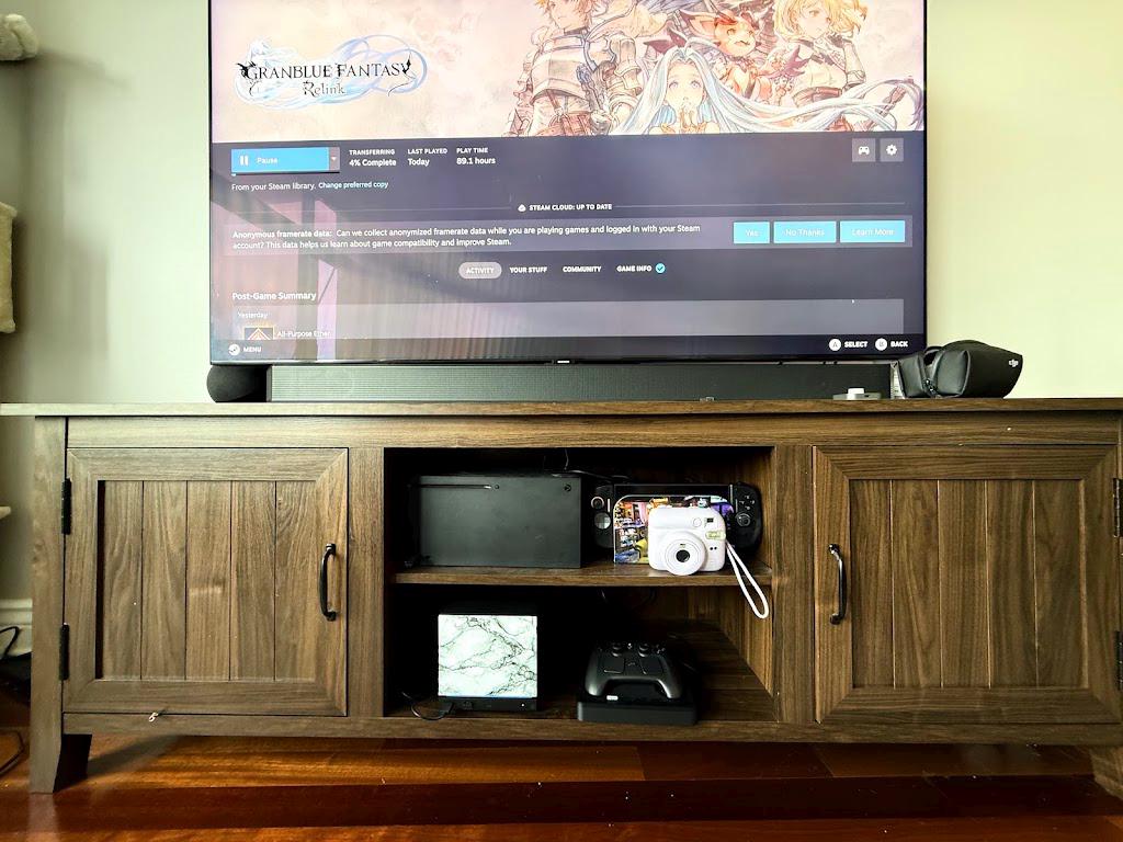 White Marble Steam Machine Faceplate | Magnetic UV Printed Panel, Minimal Desk Decor, full view of a wooden media cabinet with a TV showing Steam, the Steam Machine with the white marble faceplate installed on the open shelf below next to a Steam controller on its charging dock