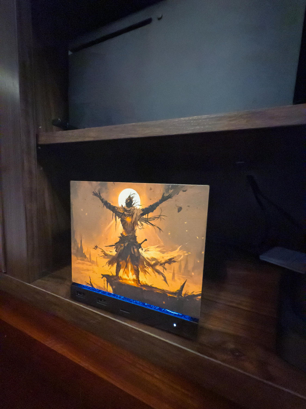 Praise the Sun Steam Machine Faceplate – Dark Fantasy Silhouette (Magnetic UV Print) with a warrior figure raising his arms before a glowing moon, shown installed on the console on a dark wooden shelf with a blue LED strip glowing at its base