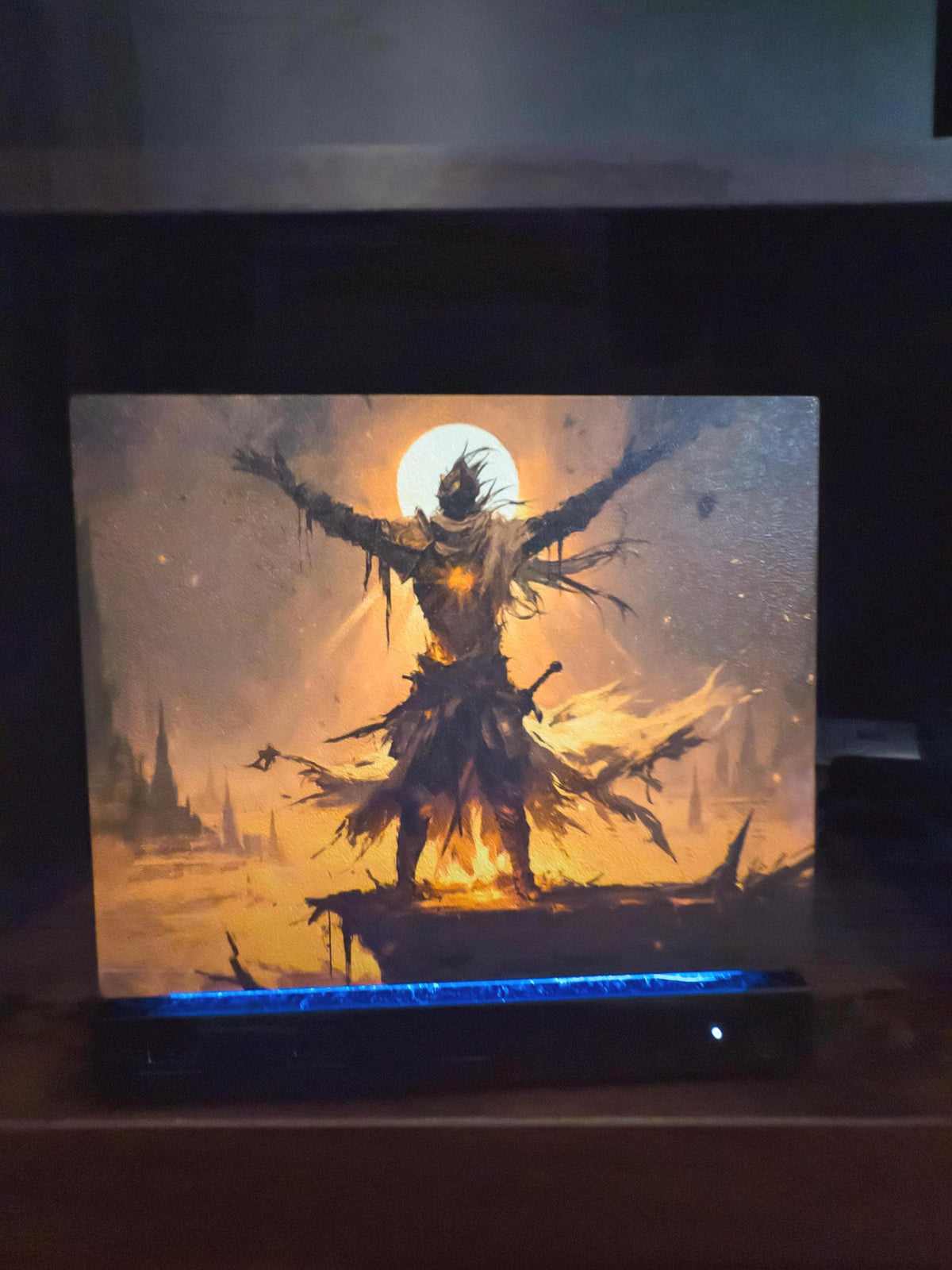 Praise the Sun Steam Machine Faceplate – Dark Fantasy Silhouette (Magnetic UV Print) with a skeletal warrior raising his arms before a glowing moon, shown installed on the console on a dark wooden surface with a blue LED strip glowing at its base