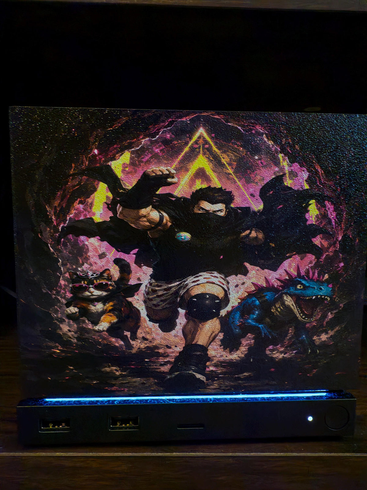 Dungeon Crawler Carl Steam Machine Faceplate | Licensed Landfin Studio Art (UV Printed) with Carl leaping through the glowing dungeon portal, close-up of the printed artwork showing Carl, Princess Donut and the blue creature, installed on the console on a wooden surface with the blue LED strip glowing at its base