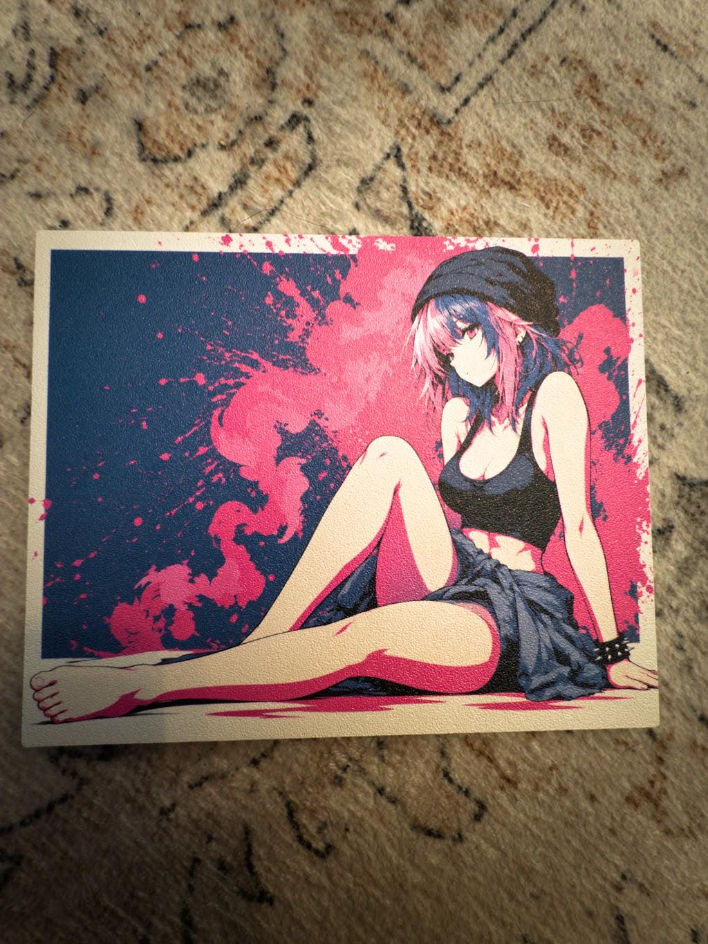Anime Pinup Art Steam Machine Faceplate | Pink Blue Splatter Print | Magnetic UV Printed Panel | Stylish Gamer Gift with the pink and blue splatter art of a seated anime girl in a black beanie, close-up straight-on view of the detached faceplate panel lying on a textured beige carpet