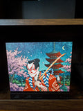 Kabuki Samurai Art Steam Machine Faceplate | Ukiyo-e Style Sword Panel | Magnetic UV Printed Cover | Japanese Gamer Gift with the kabuki actor artwork with red kumadori face paint, sword, pagoda and cherry blossoms under a starry night sky, shown installed on the console on a dark wooden shelf
