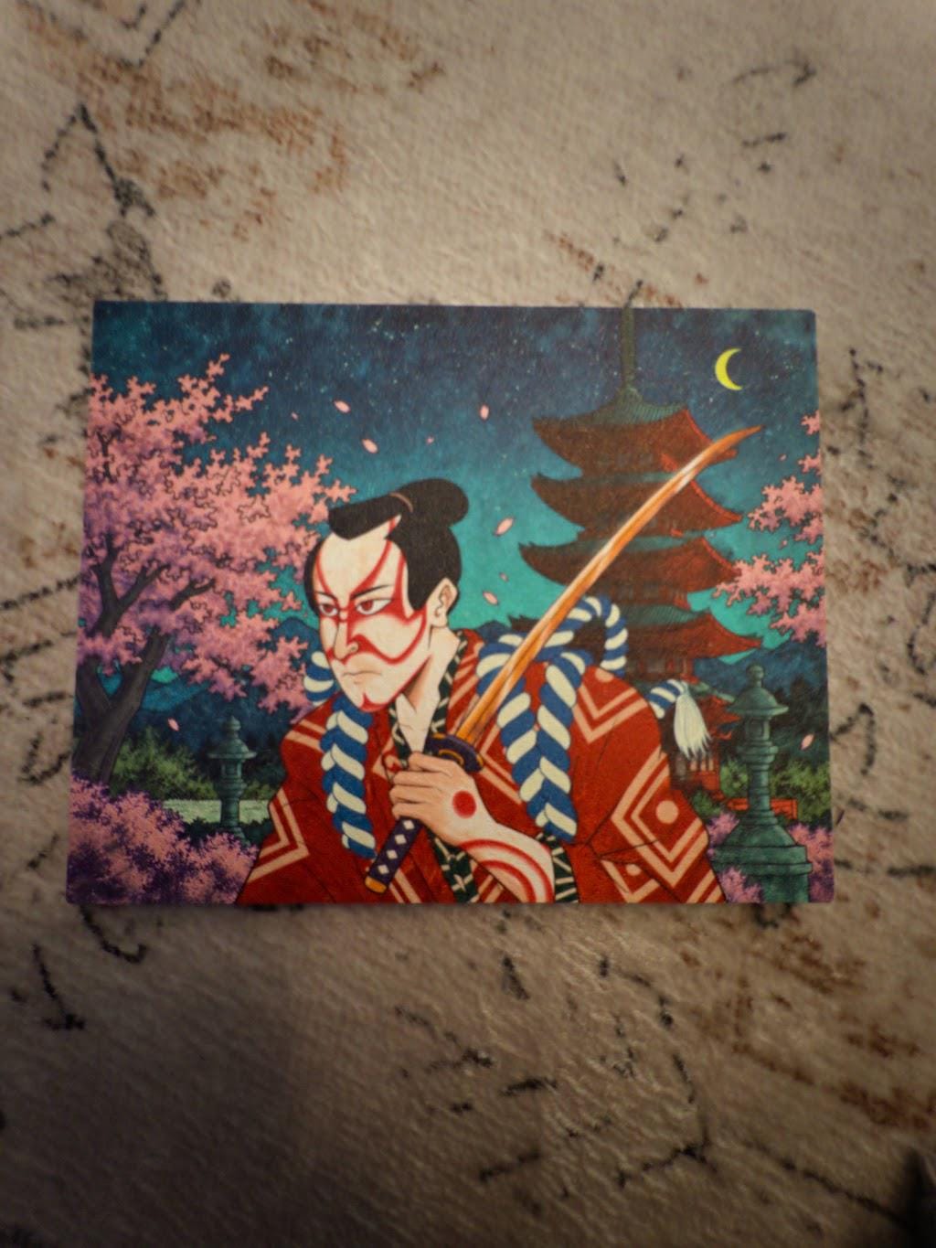 Kabuki Samurai Art Steam Machine Faceplate | Ukiyo-e Style Sword Panel | Magnetic UV Printed Cover | Japanese Gamer Gift with the kabuki actor artwork of a kabuki actor in red robes holding a drawn sword, pagoda, cherry blossoms and crescent moon at night, top-down view of the detached panel on a beige textured surface