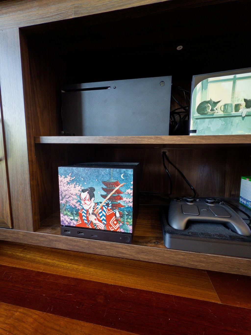 Kabuki Samurai Art Steam Machine Faceplate | Ukiyo-e Style Sword Panel | Magnetic UV Printed Cover | Japanese Gamer Gift with the kabuki actor artwork, shown installed on the console in a wooden shelf cubby beside a game controller with a larger console on the shelf above