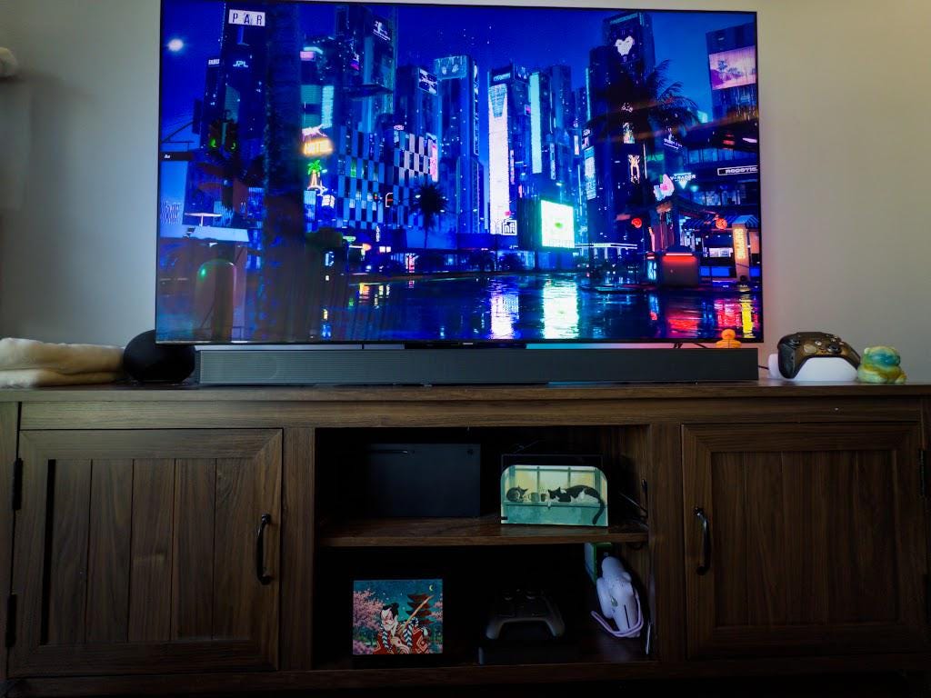 Kabuki Samurai Art Steam Machine Faceplate | Ukiyo-e Style Sword Panel | Magnetic UV Printed Cover | Japanese Gamer Gift with the kabuki actor artwork, visible on the console in the lower shelf of a wooden media console beneath a large TV showing a neon cityscape, beside a game controller