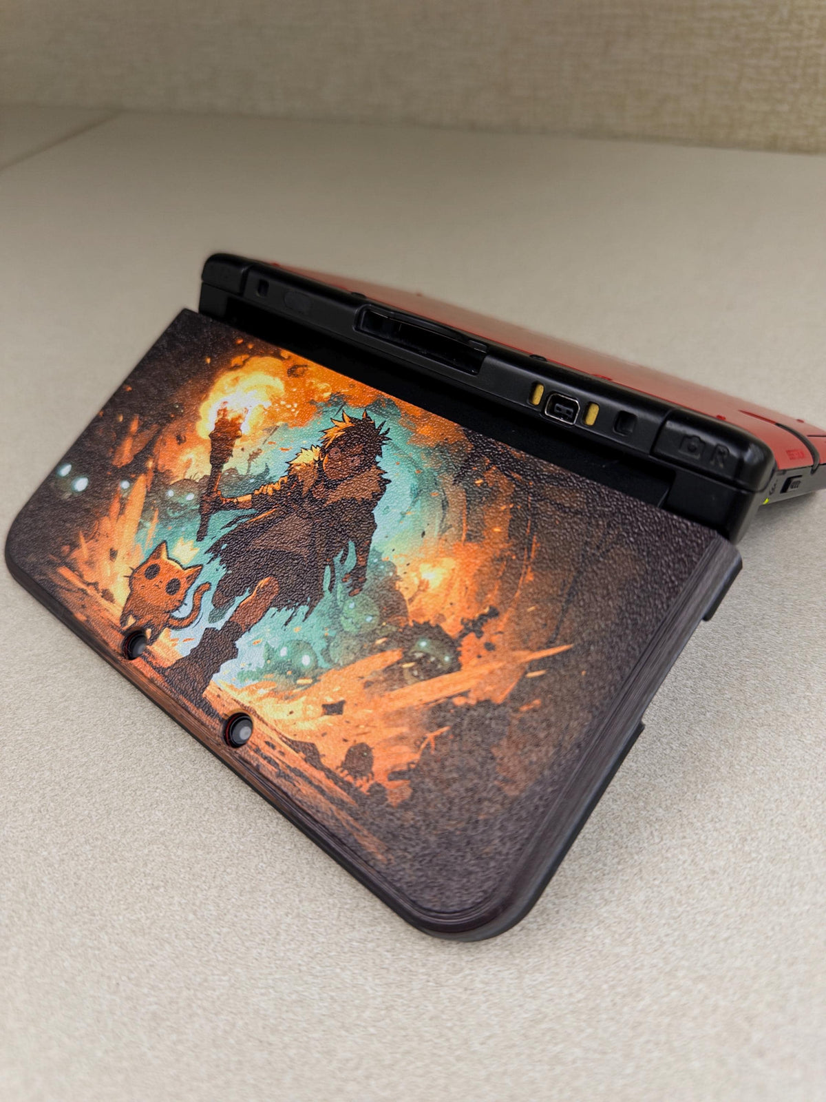 3DS XL Custom Lid, Full Color UV Printed Snap On Cover, Top Shell Faceplate for Original 3DS XL, Your Own Image, Interchangeable Lid, Torchlight fantasy artwork lid shown installed on the back of an open 3DS XL console on a light beige tabletop, with the camera cutouts visible
