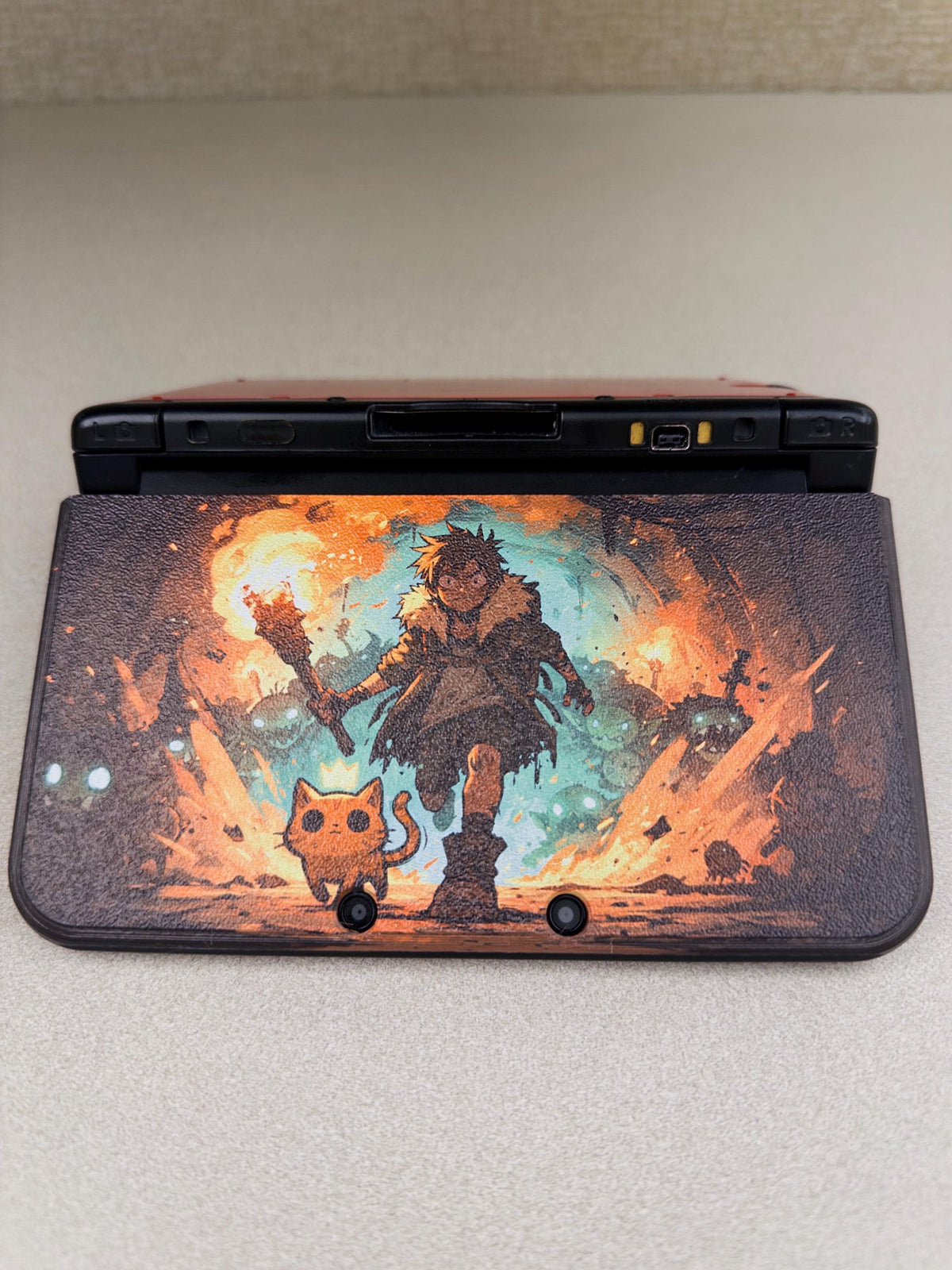 3DS XL Custom Lid, Full Color UV Printed Snap On Cover, Top Shell Faceplate for Original 3DS XL, Your Own Image, Interchangeable Lid, close-up of the Torchlight fantasy artwork lid installed on an open 3DS XL console on a light beige surface, showing the torch-holding warrior and small orange cat illustration