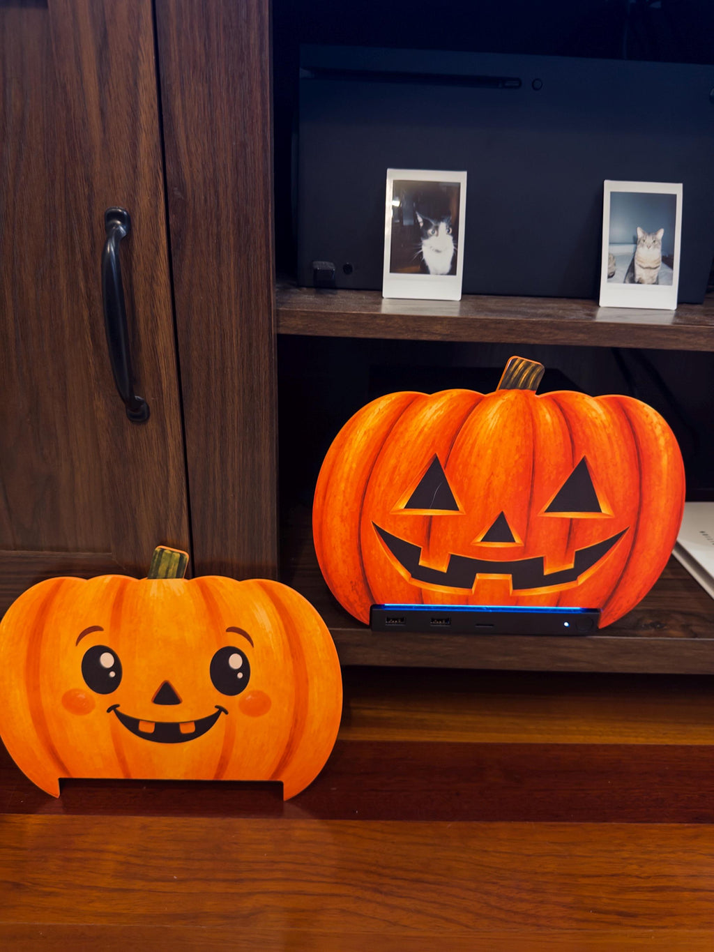 Steam Machine Faceplate Halloween Pumpkin, Classic or Cute Jack o Lantern Magnetic Plate, UV Printed Console Cover, Spooky Gamer Gif, photo showing both pumpkin designs side by side, with the cute round pumpkin faceplate leaning in front and the classic carved jack-o-lantern faceplate installed on the Steam Machine on a wooden shelf behind it