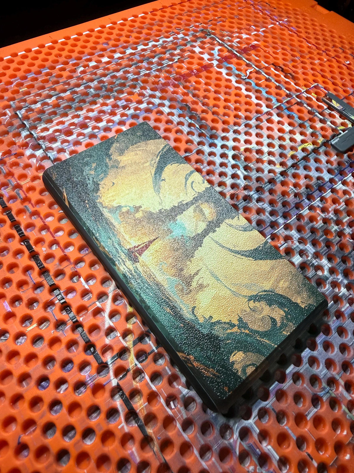 DS Lite Custom Lid, Full Color UV Printed Snap On Cover, Top Shell Faceplate for Original DS Lite, Your Own Image, Interchangeable Lid, close-up of the uninstalled lid panel printed with a green and gold marbled artwork, lying on an orange perforated build plate