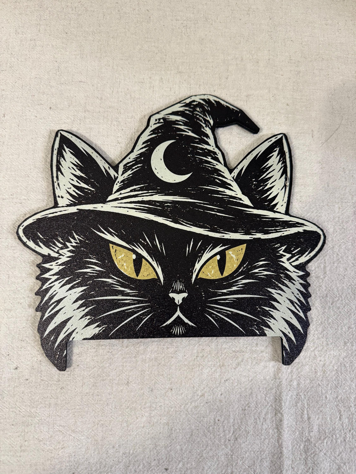 Steam Machine Faceplate Black Cat Witch Hat, Halloween Witchy Cat Magnetic Plate, UV Printed Console Cover, Spooky Gamer Gift, flat lay of the black cat witch hat faceplate's printed front showing the woodcut-style cat face with yellow eyes and crescent moon witch hat, on an off-white fabric background