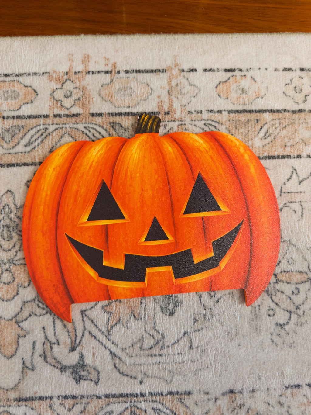 Steam Machine Faceplate Halloween Pumpkin, Classic or Cute Jack o Lantern Magnetic Plate, UV Printed Console Cover, Spooky Gamer Gif, flat lay of the uninstalled classic carved jack-o-lantern pumpkin faceplate on a patterned rug, with a wooden floor visible at the top