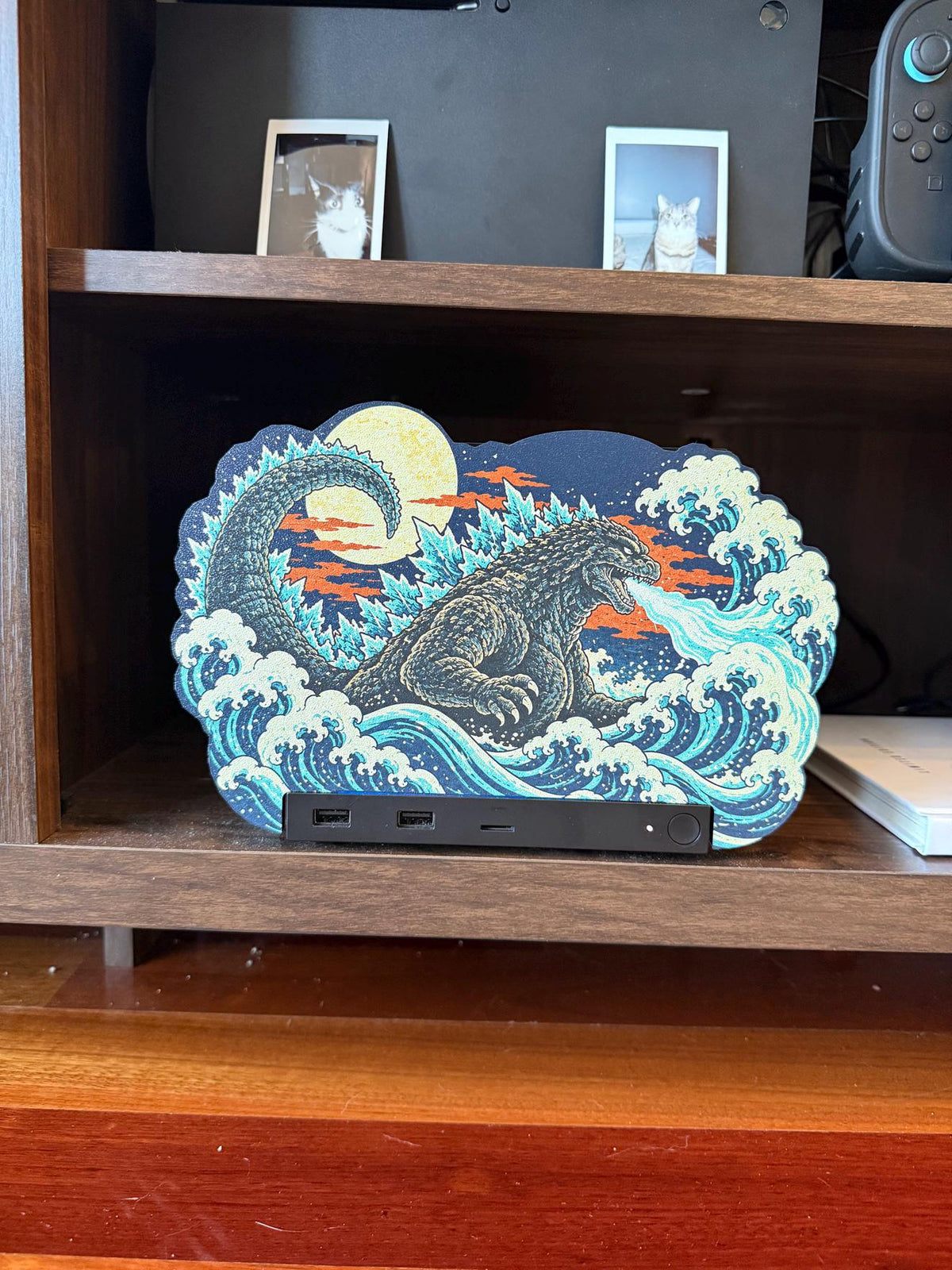 Steam Machine Faceplate, Custom Faceplate, Godzilla Kaiju Plate XL Oversized, Magnetic Console Cover, Monster Gamer Gift, Japan Wave Decor, close-up front view of the Godzilla kaiju XL faceplate installed on the console on a wooden shelf, showing the full kaiju and wave artwork with the front USB ports and power button below
