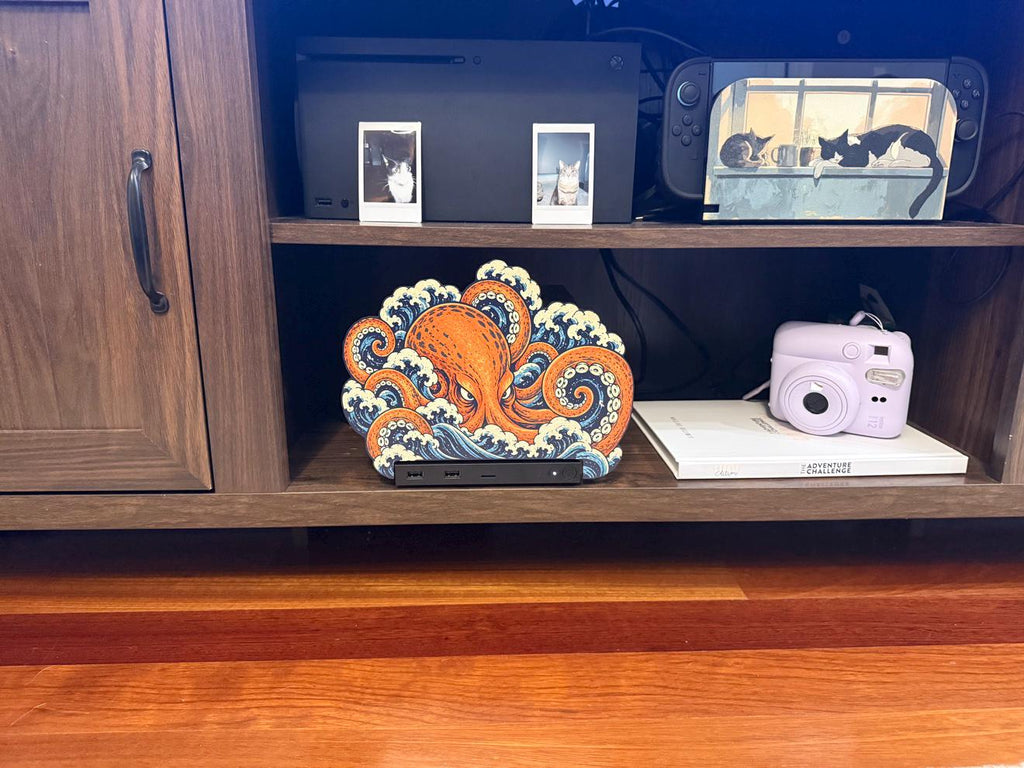 Steam Machine Faceplate, Custom Faceplate, Kraken Kaiju Plate XL Oversized, Magnetic Console Cover, Octopus Gamer Gift, Japan Wave Decor, Kraken kaiju XL faceplate installed on the console on the lower shelf of a wooden media cabinet, beside a white book with a pink instant camera on it