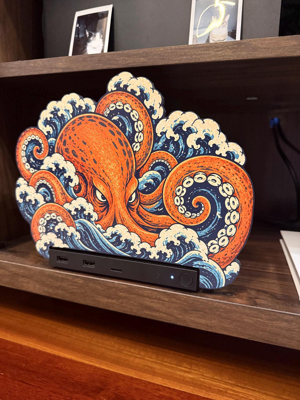 Steam Machine Faceplate, Custom Faceplate, Kraken Kaiju Plate XL Oversized, Magnetic Console Cover, Octopus Gamer Gift, Japan Wave Decor, angled view of the Kraken kaiju XL faceplate with an orange octopus rising out of Japanese waves, installed on the console on a wooden shelf beside a white book