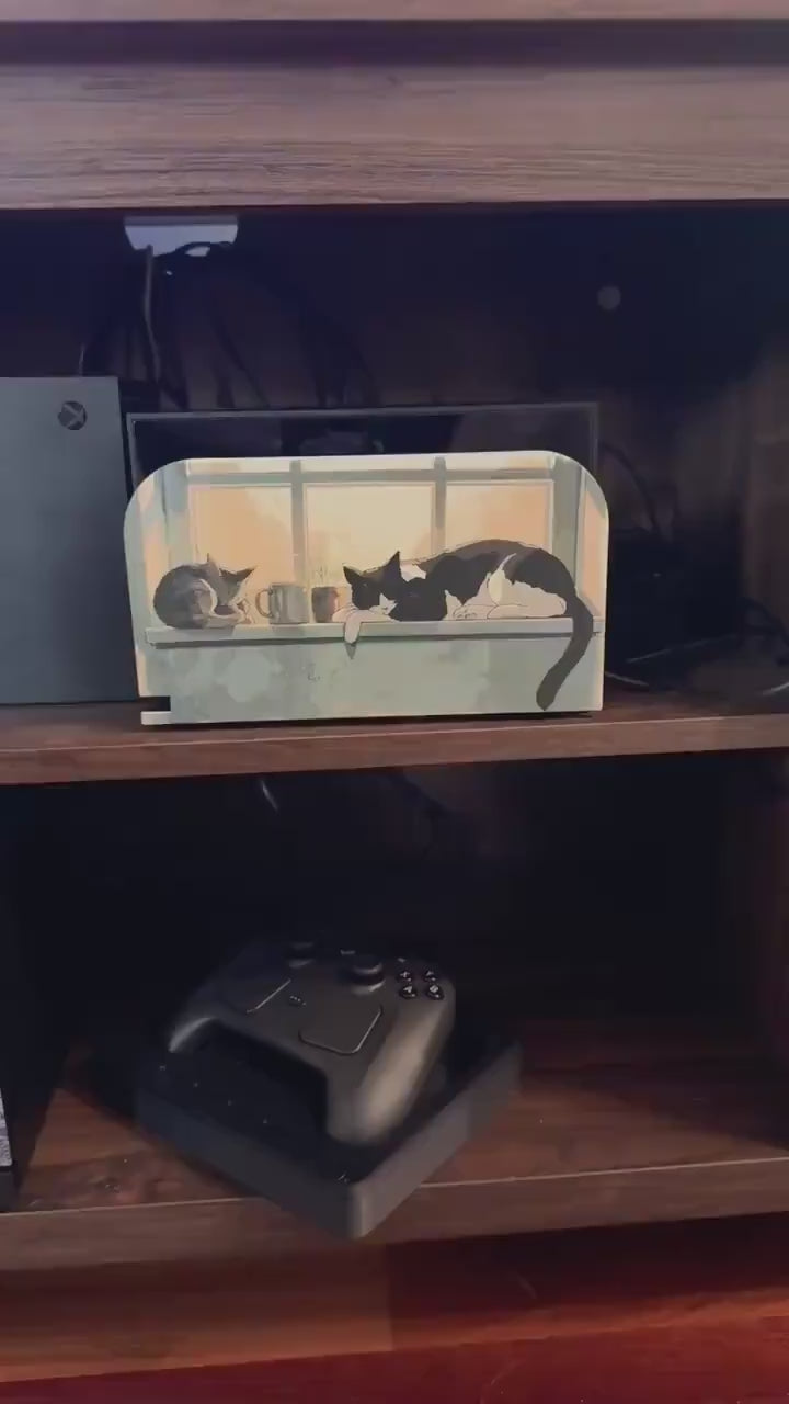 Custom 3D Printed Switch 2 Dock Faceplate, Magnetic Snap-On Cover (Personalized Photo), video showing the dock with the white cat watering flowers cottage faceplate installed on a wooden shelf, with a game controller on the shelf below
