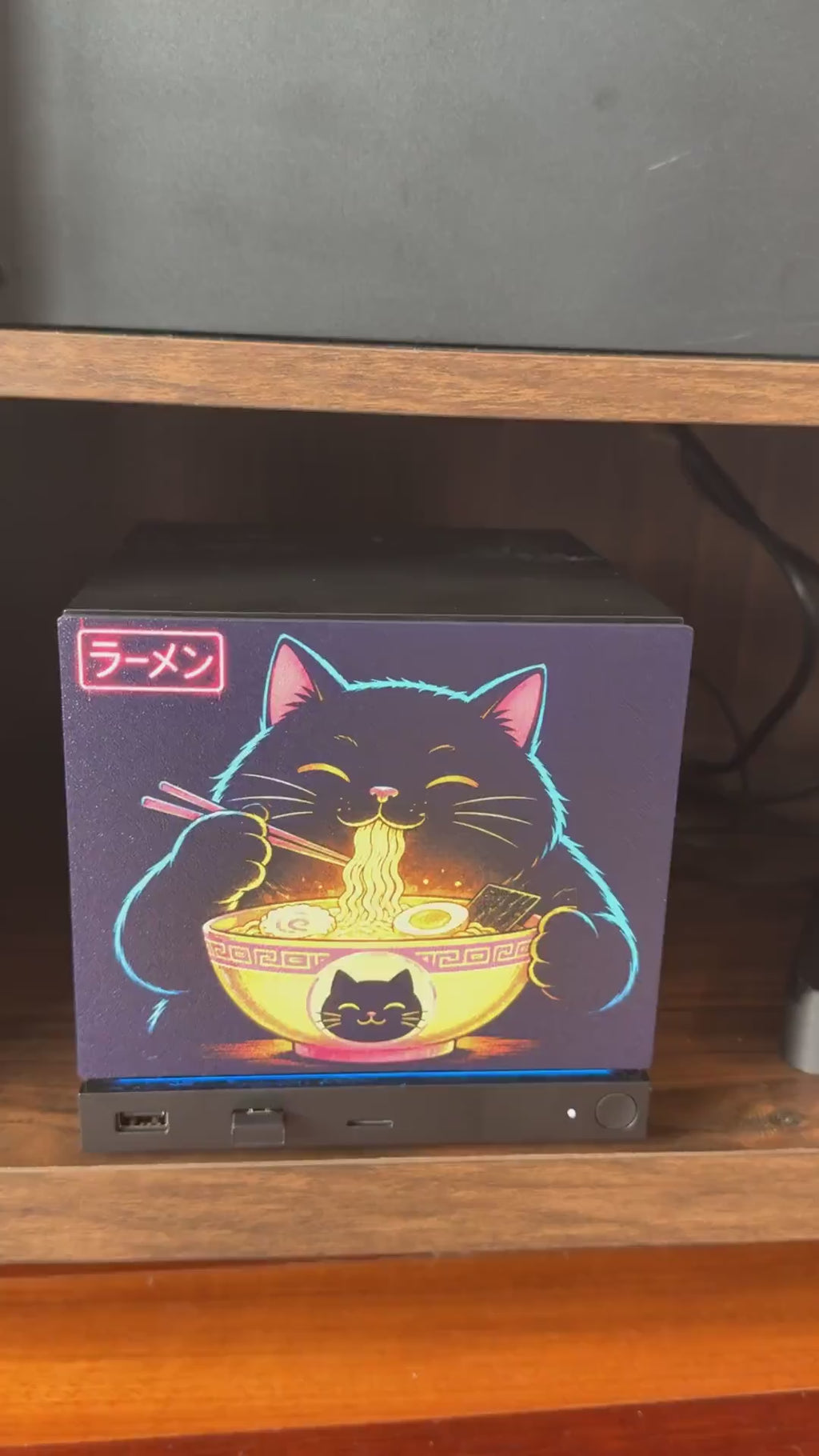 Steam Machine Faceplate Neon Ramen Cat Art | Magnetic UV Printed Panel | Kawaii Japanese Gamer Decor, video clip of hands attaching the Neon Ramen Cat faceplate onto the console in a wooden shelf